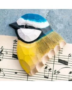 Houten koelkastmagneet Pimpelmees van Wildlife Garden met blauwe kruin, witte wangen, zwarte oogstreep en gele borst, gefotografeerd op bladmuziek.