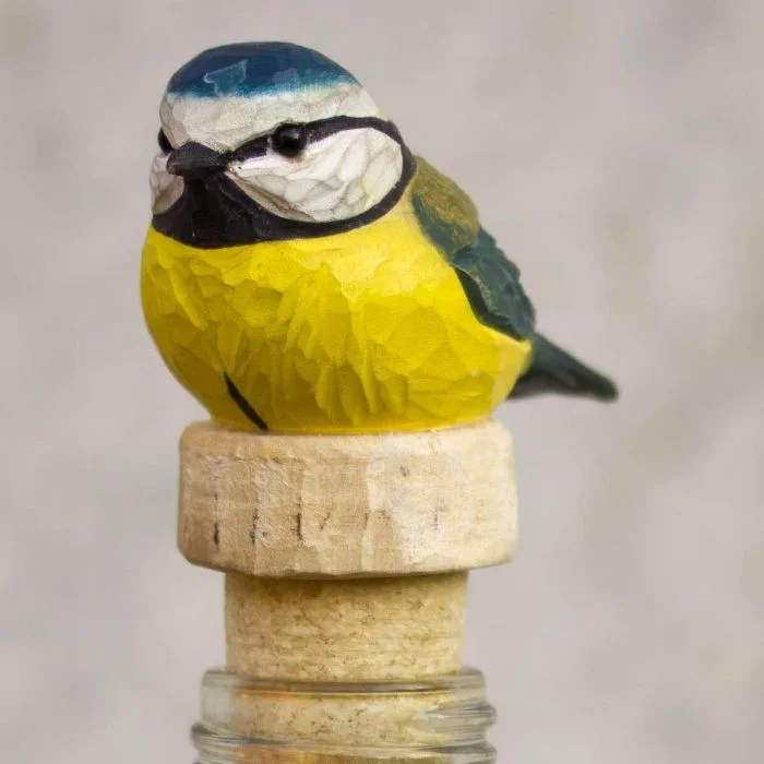 Flessenstop Pimpelmees van Wildlife Garden op een glazen fles, met handgesneden houten vogel, blauwe kop, gele borst en natuurlijke kurken stop.