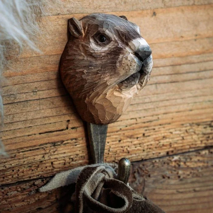 Kledinghaak Alpenmarmot van Wildlife Garden aan een rustieke houten wand, met bruin gesneden marmottenkop en een stoffen band aan de metalen haak.