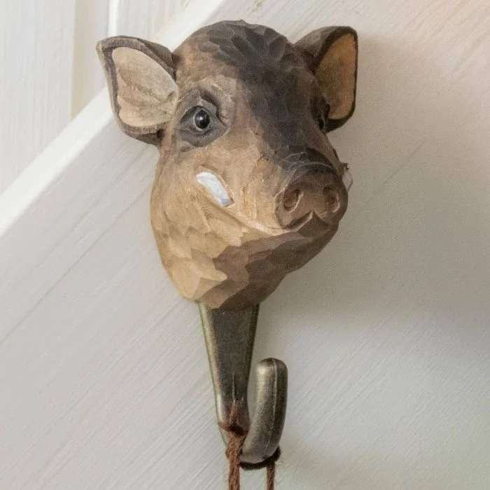 Kledinghaak Wild zwijn van Wildlife Garden aan een lichte wand, met handgesneden zwijnenkop, metalen haak en een bruin koord eraan.