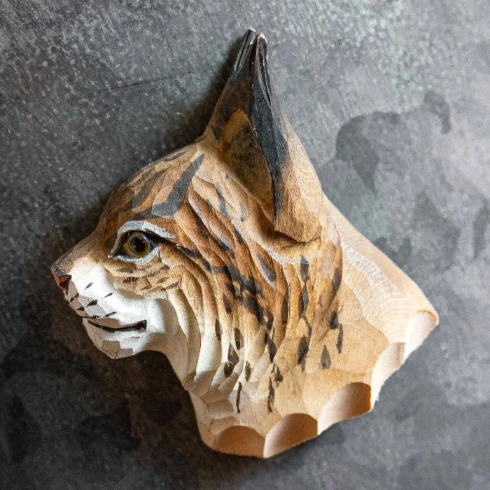 Houten koelkastmagneet Lynx van Wildlife Garden met spitse oren, zwarte oorpluimen en gevlekte bruinbeige vacht, bevestigd op een donkergrijze metalen ondergrond.