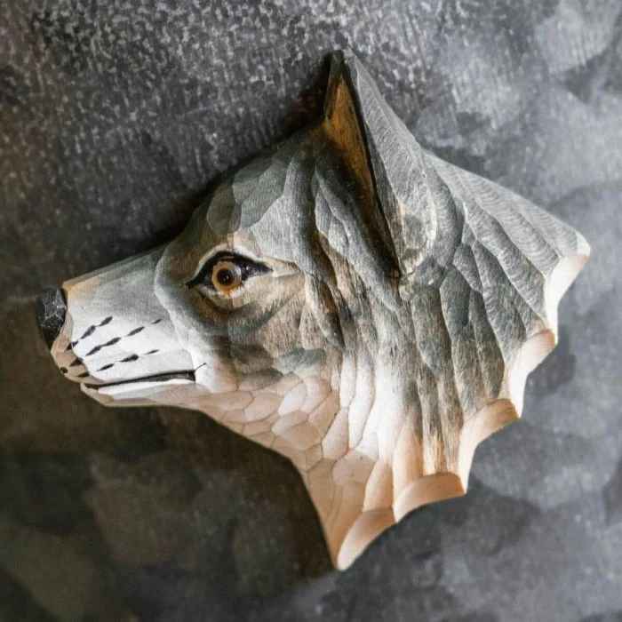 Houten koelkastmagneet Grijze Wolf van Wildlife Garden met grijsbruine vacht, spitse oren en witte snuit, bevestigd op een donkergrijze metalen ondergrond.