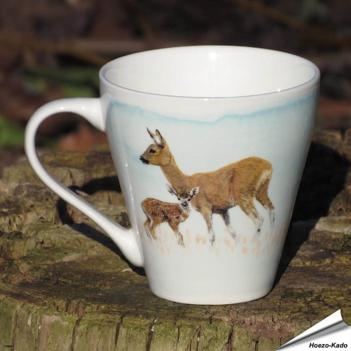 De porseleinen mok is een prachtig stukje handwerk, met een afbeelding van een hert en haar jong.